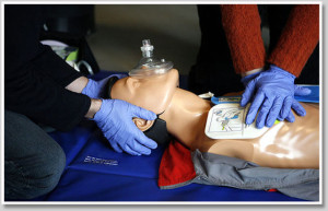 students practicing CPR with pocket mask on dummy